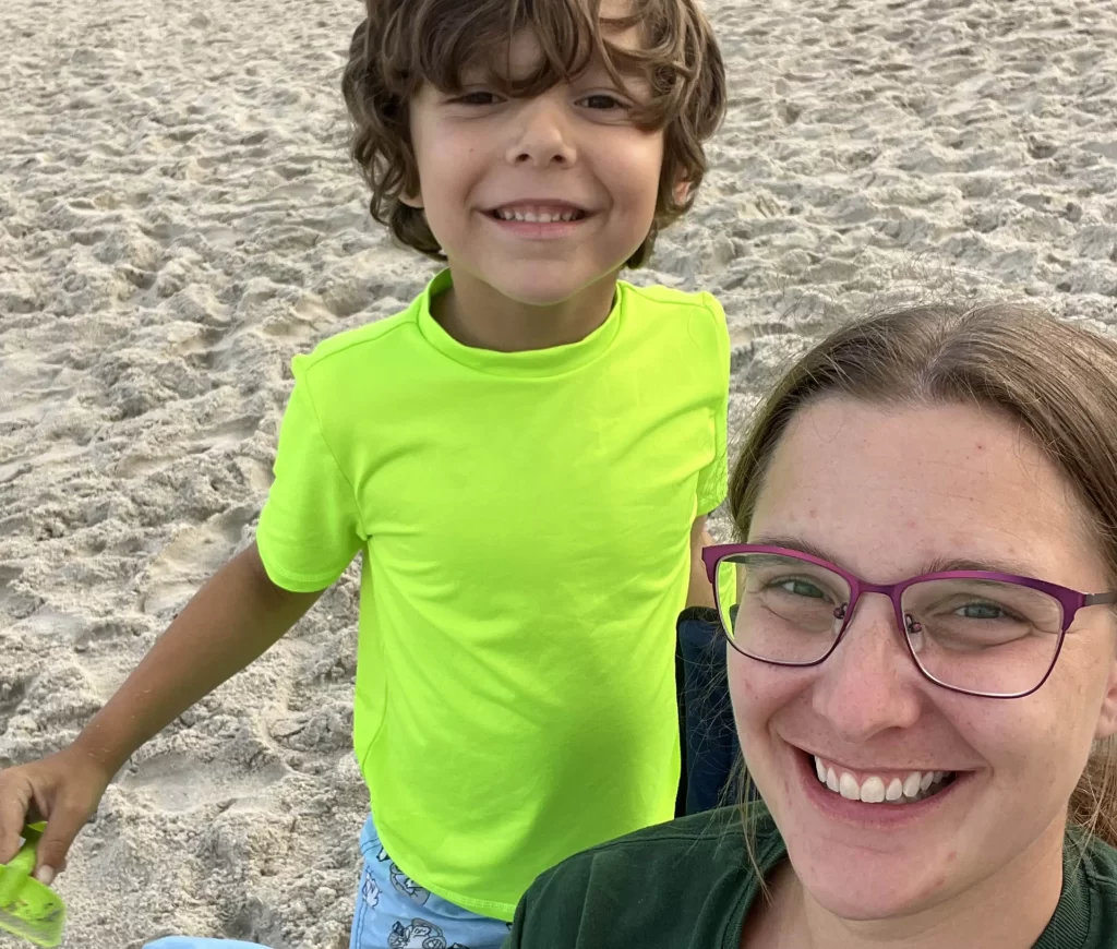 happy boy with mom on beach smiling