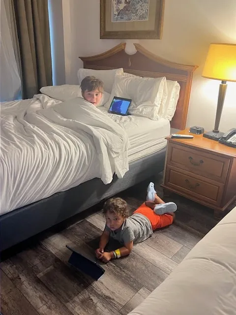 two young boys watching movies in hotel room