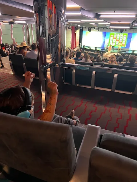 Child wearing headphones sits in theater playing bingo.