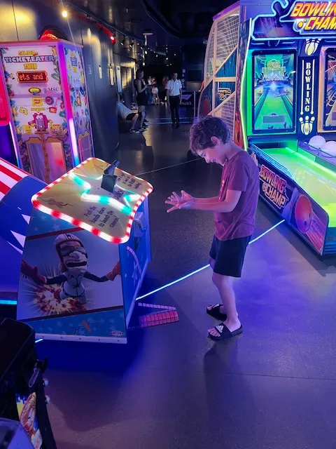 A boy plays an arcade game winning tickets.