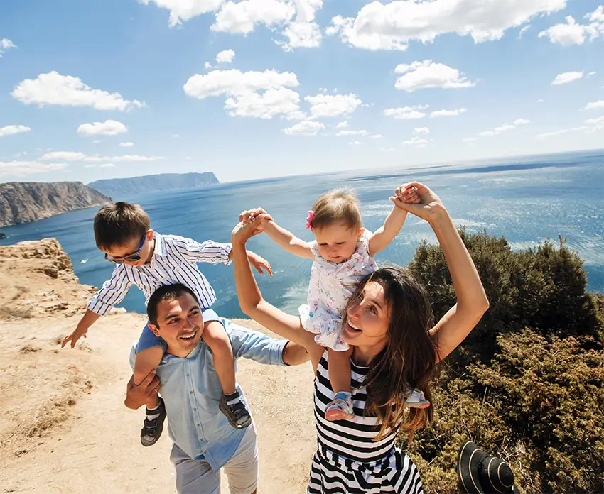 Happy family with mom, dad, and 2 kids having fun.